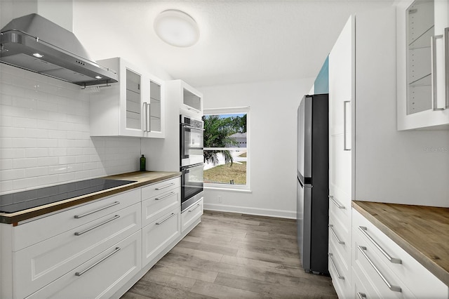 23 Essington Ln, Palm Coast, FL 32164 - kitchen with range hood, stainless steel appliances, butcher block counters, and wood finished floors