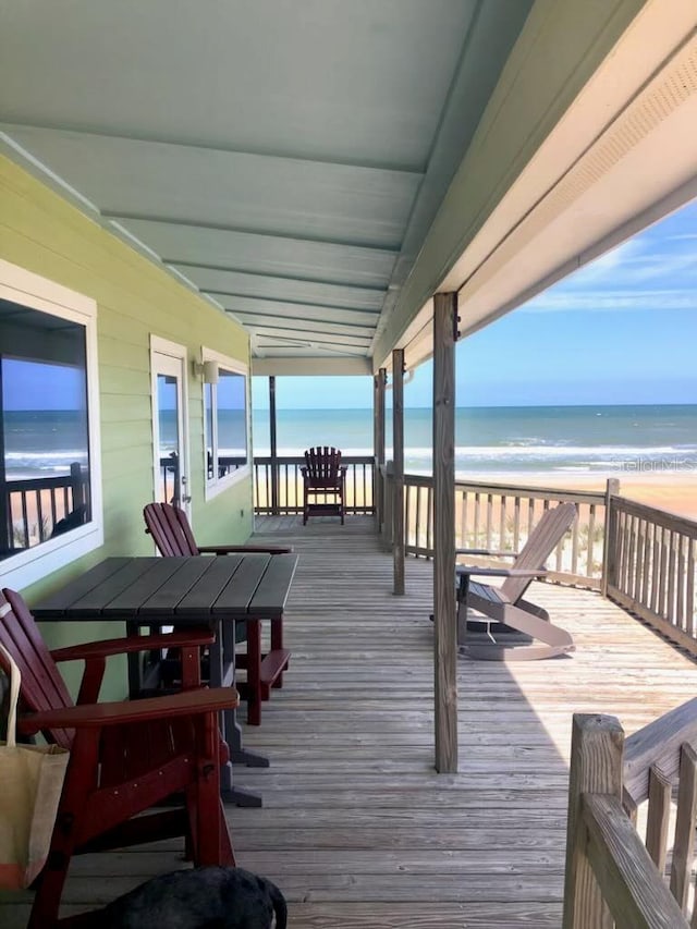 wooden terrace with a view of the beach and a water view