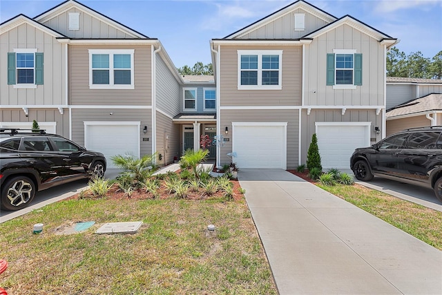 view of property with board and batten siding, an attached garage, and driveway