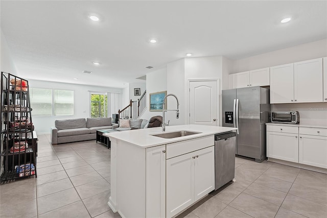 kitchen with light countertops, white cabinets, a sink, light tile patterned floors, and stainless steel appliances