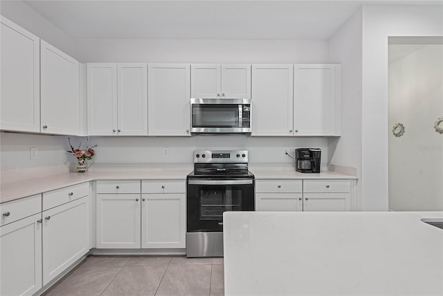 kitchen featuring light countertops, appliances with stainless steel finishes, white cabinets, and light tile patterned flooring