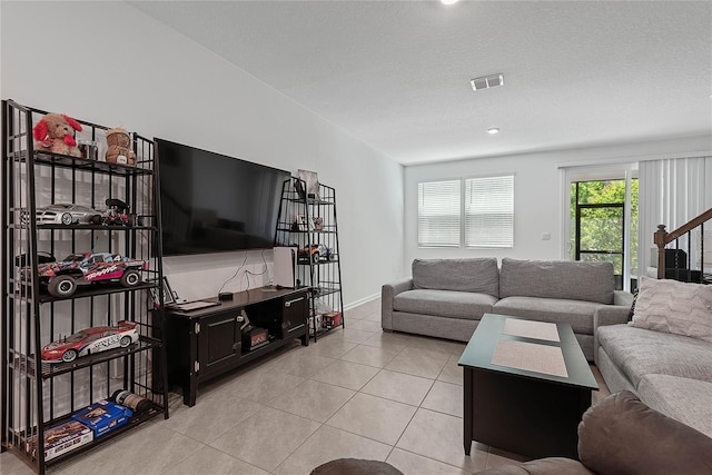 living area featuring baseboards, light tile patterned flooring, and visible vents