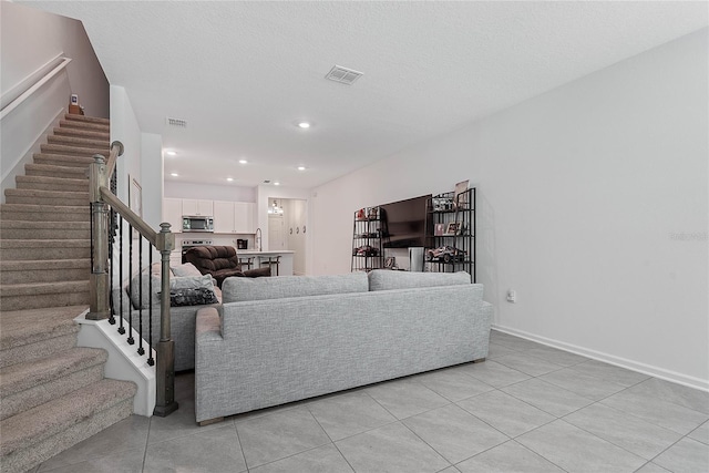 living area with visible vents, recessed lighting, stairs, and light tile patterned floors