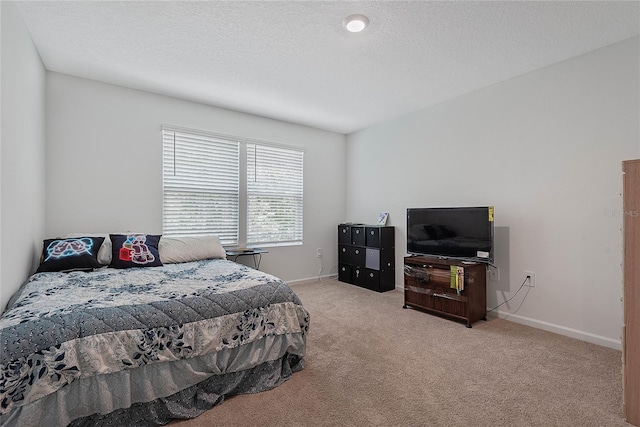 bedroom with light colored carpet and baseboards