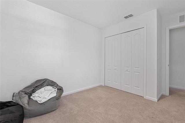 unfurnished room featuring baseboards, visible vents, and light colored carpet