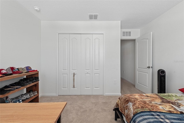 bedroom featuring baseboards, light carpet, a closet, and visible vents