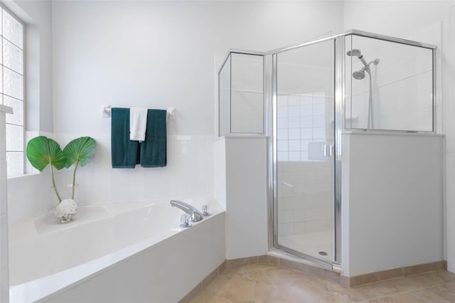 bathroom with a garden tub, baseboards, tile patterned flooring, and a shower stall