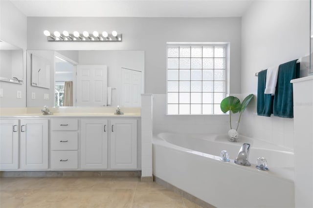 bathroom featuring a garden tub, double vanity, a sink, and tile patterned floors