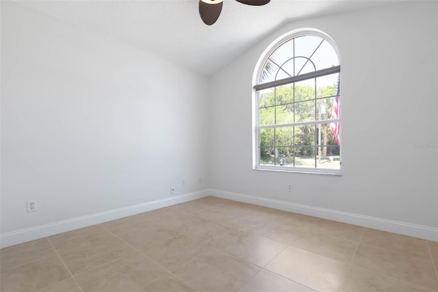 spare room featuring baseboards, ceiling fan, lofted ceiling, and light tile patterned floors