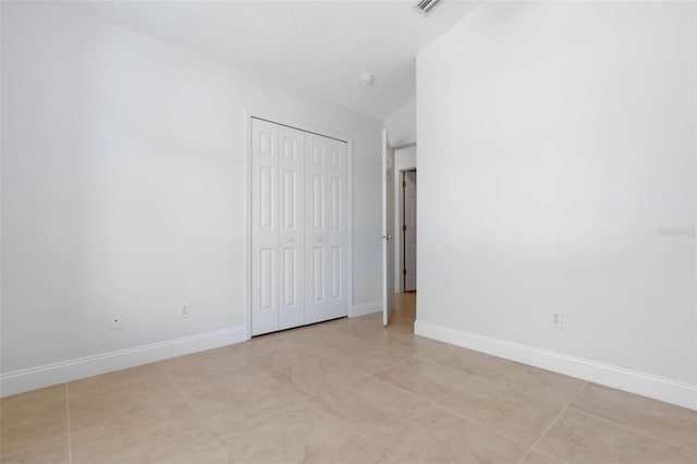 unfurnished bedroom featuring baseboards and a closet