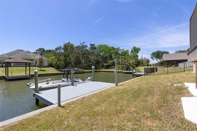 dock area featuring a gazebo, a water view, fence, and a yard