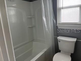 full bath with toilet and shower / tub combo with curtain