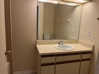 bathroom featuring vanity, toilet, and baseboards