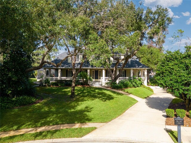 view of front of property with a porch, a front lawn, and concrete driveway