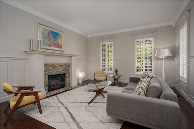 living area with a decorative wall, wood finished floors, ornamental molding, a fireplace, and a wainscoted wall