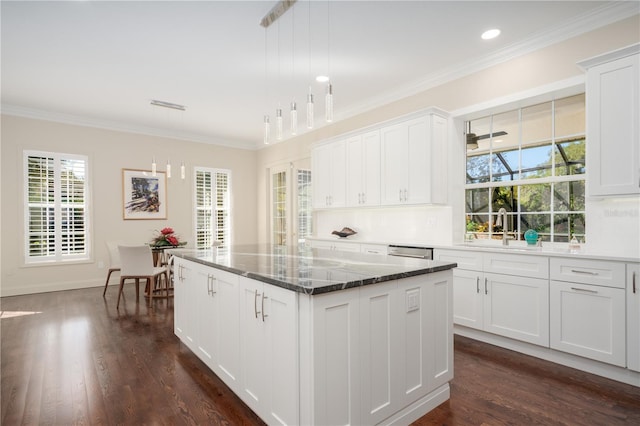 kitchen featuring a sink, a kitchen island, crown molding, plenty of natural light, and dark wood-style flooring
