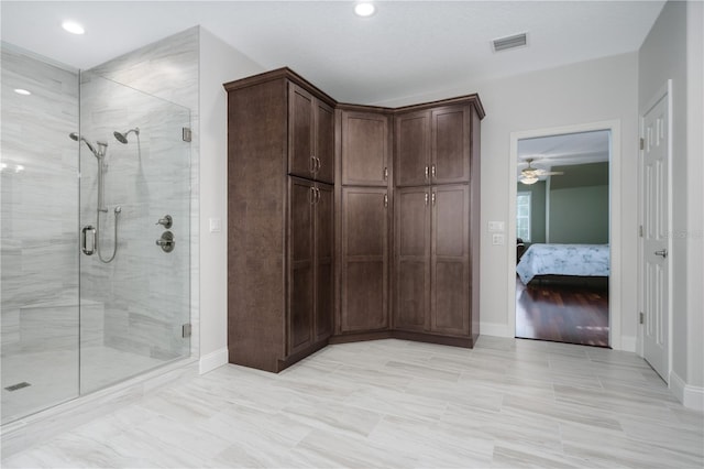 ensuite bathroom featuring a stall shower, baseboards, a ceiling fan, and recessed lighting