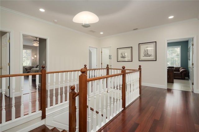 hallway with an upstairs landing, crown molding, wood finished floors, baseboards, and recessed lighting
