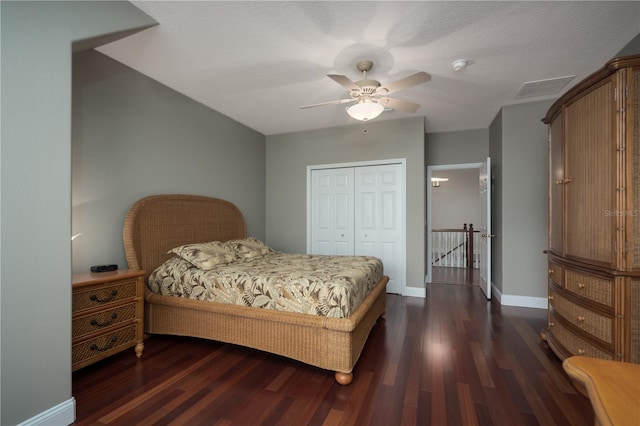 bedroom featuring dark wood-type flooring, a closet, baseboards, and ceiling fan