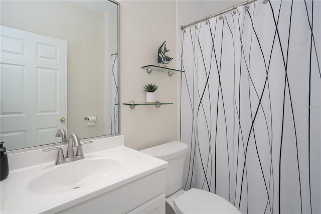 bathroom featuring toilet, vanity, and curtained shower