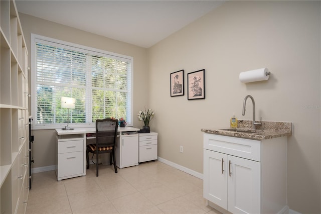 home office featuring a sink, baseboards, and light tile patterned floors