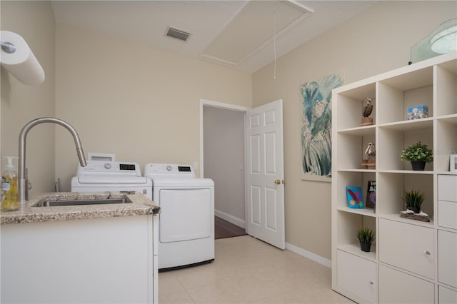 clothes washing area with attic access, washing machine and dryer, cabinet space, baseboards, and light tile patterned flooring