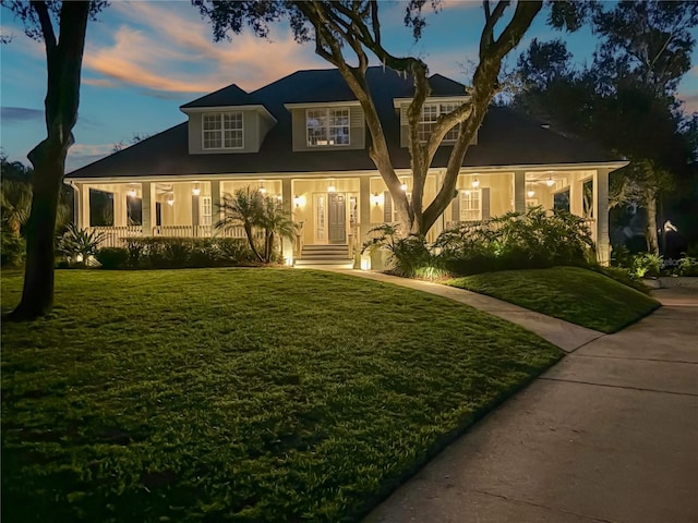 view of front of house with a yard and a porch