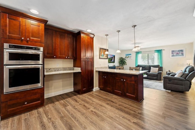 25 Westlawn Pl, Palm Coast, FL 32164 - kitchen featuring double oven, a peninsula, dark wood-style floors, open floor plan, and recessed lighting