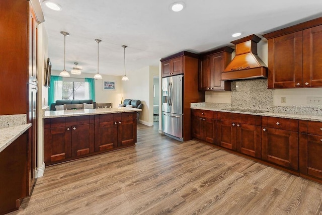25 Westlawn Pl, Palm Coast, FL 32164 - kitchen featuring light wood-style floors, premium range hood, open floor plan, decorative backsplash, and stainless steel refrigerator with ice dispenser