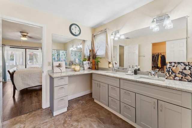 25 Westlawn Pl, Palm Coast, FL 32164 - ensuite bathroom featuring double vanity, a sink, connected bathroom, and baseboards