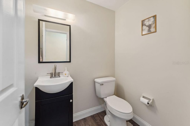 25 Westlawn Pl, Palm Coast, FL 32164 - half bathroom featuring toilet, baseboards, wood finished floors, and vanity