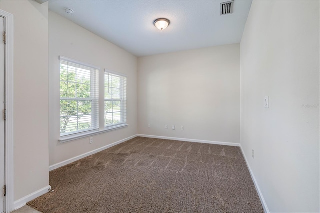 carpeted spare room with baseboards and a smoke detector