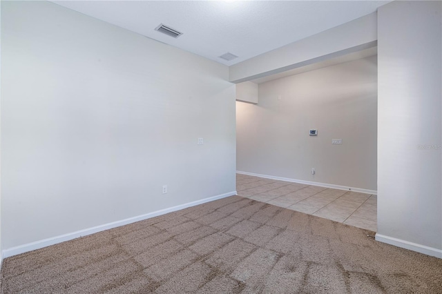 unfurnished room with carpet, baseboards, and tile patterned floors