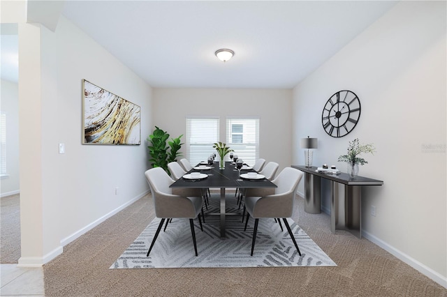 carpeted dining area featuring baseboards