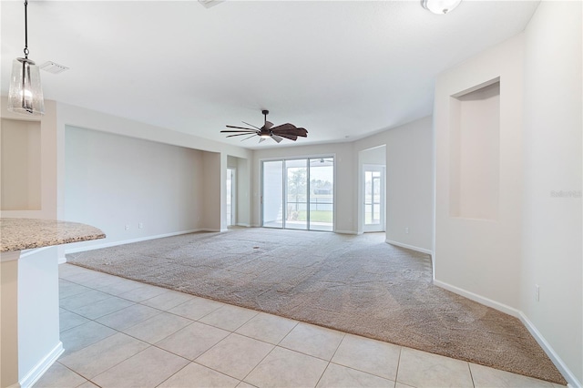 unfurnished living room featuring light colored carpet, ceiling fan, light tile patterned floors, and baseboards