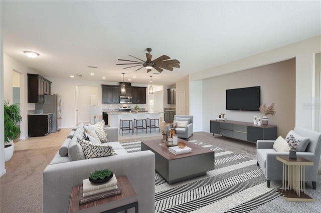 living area with light carpet, ceiling fan, recessed lighting, baseboards, and light tile patterned floors