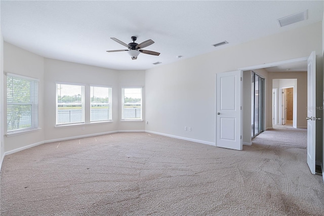 spare room with carpet, ceiling fan, and baseboards