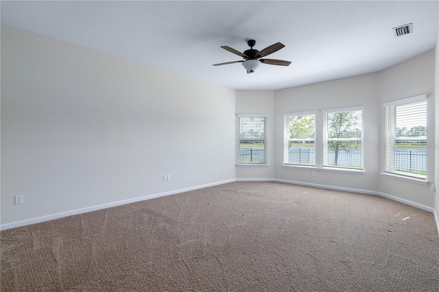carpeted empty room with baseboards, plenty of natural light, and a ceiling fan