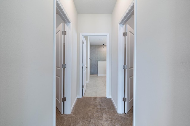 hallway featuring carpet flooring and baseboards