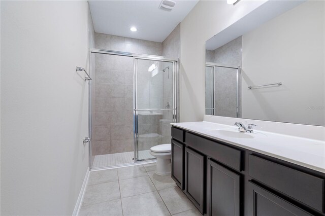 bathroom with a stall shower, tile patterned flooring, toilet, vanity, and baseboards