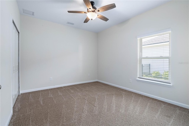 carpeted empty room with ceiling fan and baseboards