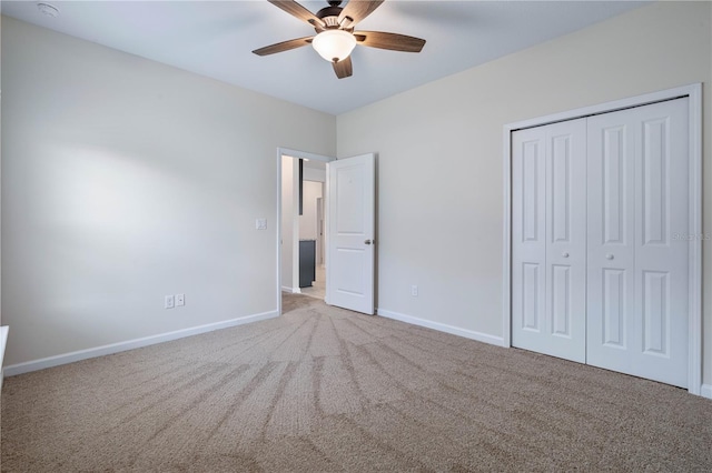 unfurnished bedroom featuring carpet floors, baseboards, a closet, and a ceiling fan