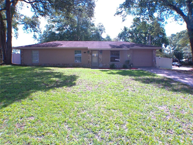 ranch-style home with an attached garage, stucco siding, driveway, and a front yard