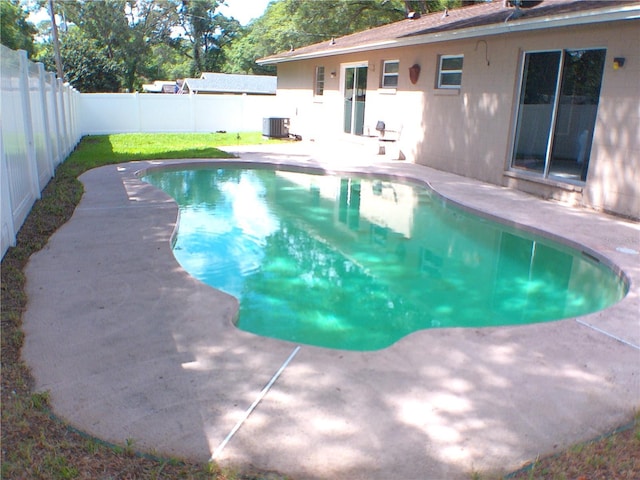 view of swimming pool featuring central air condition unit, a patio area, a fenced backyard, and a fenced in pool