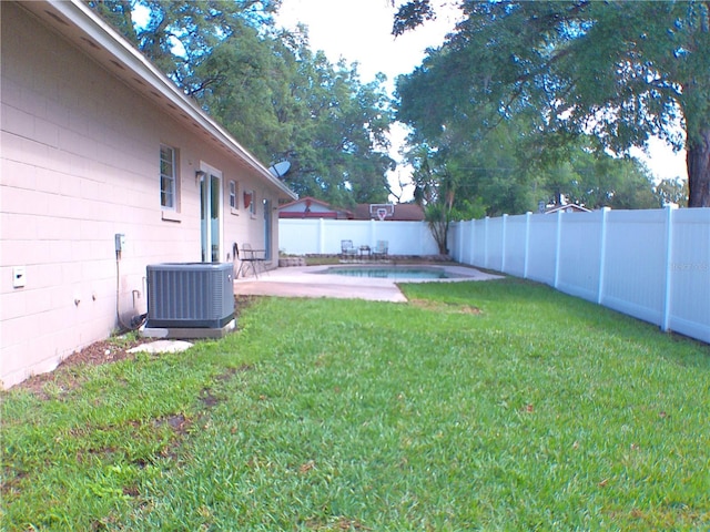 view of yard with a fenced backyard, a patio, a fenced in pool, and central AC