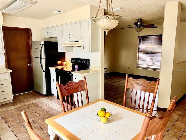 kitchen featuring freestanding refrigerator, visible vents, under cabinet range hood, black electric range, and a ceiling fan