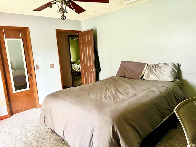 carpeted bedroom with a textured ceiling and a ceiling fan