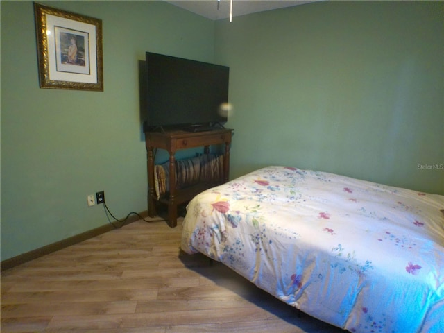 bedroom with light wood-type flooring and baseboards