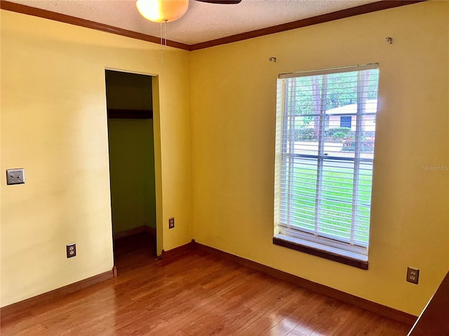 spare room featuring a textured ceiling, baseboards, a ceiling fan, and wood finished floors