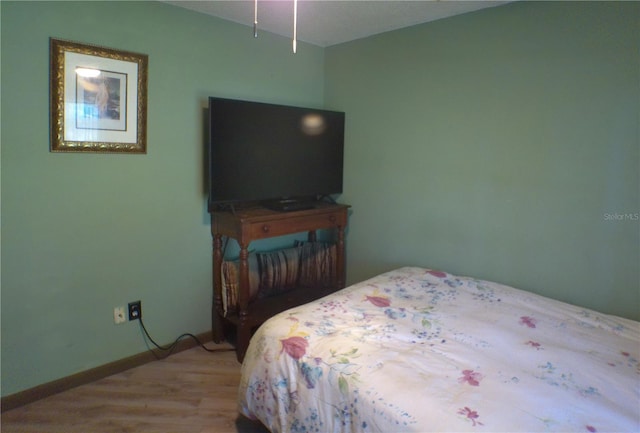 bedroom with wood finished floors and baseboards